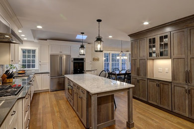 Large farmhouse l-shaped light wood floor eat-in kitchen photo in Boston with an undermount sink, recessed-panel cabinets, white cabinets, granite countertops, beige backsplash, ceramic backsplash, stainless steel appliances and an island