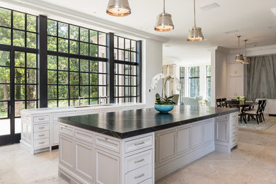Inspiration for a huge timeless limestone floor and beige floor eat-in kitchen remodel in Dallas with an undermount sink, recessed-panel cabinets, white cabinets, quartzite countertops, gray backsplash, stone slab backsplash, white appliances, two islands and white countertops