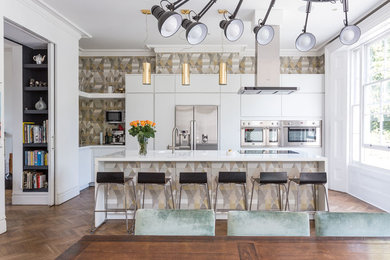 Inspiration for a contemporary l-shaped dark wood floor eat-in kitchen remodel in Kent with flat-panel cabinets, white cabinets, solid surface countertops, an island, brown backsplash and stainless steel appliances