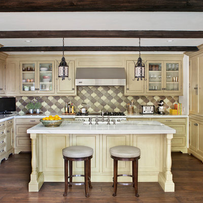 Kitchen - mediterranean l-shaped kitchen idea in Los Angeles with marble countertops, recessed-panel cabinets, yellow cabinets, multicolored backsplash and stainless steel appliances