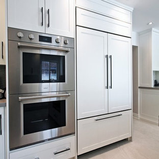 This is an example of a large contemporary u-shaped separate kitchen in Toronto with an undermount sink, shaker cabinets, white cabinets, marble benchtops, multi-coloured splashback, mosaic tile splashback, stainless steel appliances, marble floors, with island, beige floor and white benchtop.