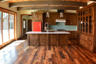 Open concept kitchen - large craftsman single-wall dark wood floor and multicolored floor open concept kitchen idea in Denver with a drop-in sink, shaker cabinets, dark wood cabinets, granite countertops, blue backsplash, glass tile backsplash, colored appliances and an island
