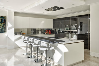 Design ideas for a large modern l-shaped open plan kitchen in Kent with a built-in sink, flat-panel cabinets, white cabinets, engineered stone countertops, grey splashback, mirror splashback, integrated appliances, porcelain flooring and an island.