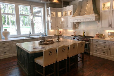 Example of a large classic l-shaped dark wood floor and brown floor eat-in kitchen design in Cleveland with an undermount sink, raised-panel cabinets, white cabinets, granite countertops, white backsplash, subway tile backsplash, stainless steel appliances and an island