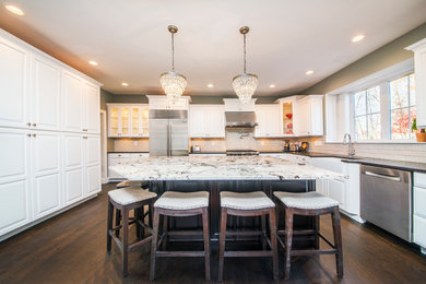 Eat-in kitchen - large transitional u-shaped dark wood floor eat-in kitchen idea in Boston with a farmhouse sink, raised-panel cabinets, white cabinets, marble countertops, white backsplash, subway tile backsplash, stainless steel appliances and an island