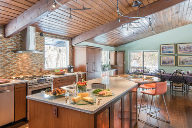 Eat-in kitchen - large craftsman l-shaped light wood floor eat-in kitchen idea in Boston with an undermount sink, flat-panel cabinets, medium tone wood cabinets, granite countertops, multicolored backsplash, mosaic tile backsplash, stainless steel appliances and an island