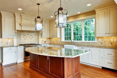 Elegant l-shaped medium tone wood floor kitchen photo in Philadelphia with a farmhouse sink, stainless steel appliances and an island
