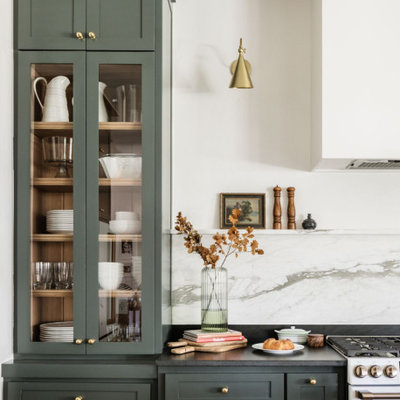 Large transitional l-shaped light wood floor and brown floor open concept kitchen photo in Oklahoma City with an undermount sink, shaker cabinets, green cabinets, quartzite countertops, white backsplash, marble backsplash, white appliances, two islands and black countertops