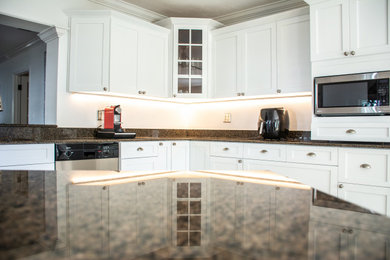 Example of a mid-sized transitional eat-in kitchen design in Miami with a single-bowl sink, shaker cabinets, white cabinets, granite countertops, black backsplash, granite backsplash, stainless steel appliances, a peninsula and black countertops