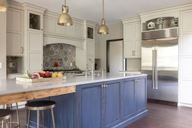 Example of a large french country l-shaped brown floor eat-in kitchen design in Detroit with an undermount sink, recessed-panel cabinets, distressed cabinets, quartz countertops, multicolored backsplash, mosaic tile backsplash, stainless steel appliances, an island and white countertops
