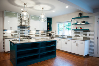Example of a trendy l-shaped medium tone wood floor eat-in kitchen design in Charlotte with a double-bowl sink, flat-panel cabinets, white cabinets, multicolored backsplash, stainless steel appliances, an island, granite countertops and ceramic backsplash