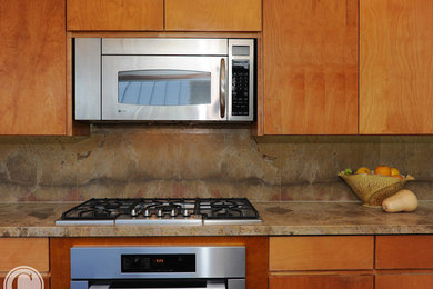 Modelo de cocina contemporánea de tamaño medio con armarios con paneles lisos, puertas de armario de madera oscura, suelo de baldosas de terracota y una isla