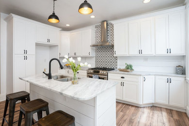 Example of a mid-sized farmhouse galley light wood floor, brown floor and wood ceiling eat-in kitchen design in St Louis with a drop-in sink, shaker cabinets, white cabinets, marble countertops, white backsplash, shiplap backsplash, stainless steel appliances, an island and gray countertops