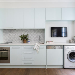 This is an example of a small contemporary single-wall kitchen in Brisbane with an undermount sink, quartz benchtops, grey splashback, marble splashback, no island, flat-panel cabinets, blue cabinets, brown floor and grey benchtop.