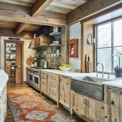 Kitchen - rustic galley medium tone wood floor and brown floor kitchen idea in Burlington with a farmhouse sink, shaker cabinets, light wood cabinets, gray backsplash, stone tile backsplash, stainless steel appliances, an island and white countertops