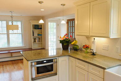 Eat-in kitchen - traditional l-shaped eat-in kitchen idea in Boston with a farmhouse sink, recessed-panel cabinets, white cabinets and stainless steel appliances