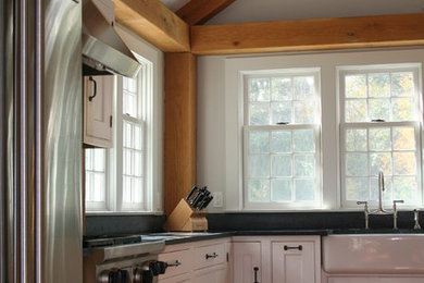 Farmhouse l-shaped eat-in kitchen photo in Boston with a farmhouse sink, recessed-panel cabinets, white cabinets, stainless steel appliances and soapstone countertops