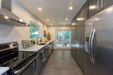 Inspiration for a mid-sized transitional galley porcelain tile enclosed kitchen remodel in Birmingham with an undermount sink, flat-panel cabinets, gray cabinets, quartz countertops, stainless steel appliances and no island