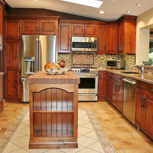 Mid-sized southwestern open concept kitchen inspiration - Mid-sized southwest u-shaped ceramic tile open concept kitchen photo in Phoenix with an undermount sink, stainless steel appliances, an island, recessed-panel cabinets, dark wood cabinets, granite countertops, beige backsplash and matchstick tile backsplash