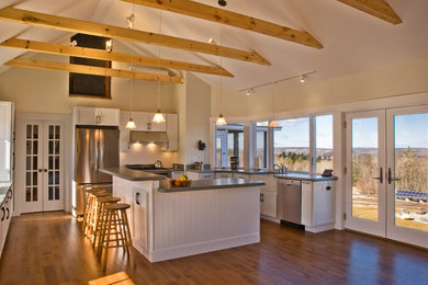 Inspiration for a large timeless u-shaped medium tone wood floor and brown floor eat-in kitchen remodel in Portland Maine with shaker cabinets, white cabinets, an island, concrete countertops, a farmhouse sink, white backsplash and stainless steel appliances