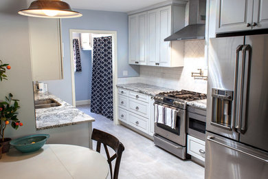 Photo of a small classic galley kitchen/diner in Boise with a submerged sink, raised-panel cabinets, white cabinets, granite worktops, white splashback, ceramic splashback, stainless steel appliances, ceramic flooring and no island.