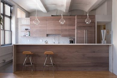 Cette photo montre une cuisine ouverte parallèle tendance en bois foncé de taille moyenne avec un placard à porte plane, un plan de travail en granite et îlot.