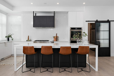 Inspiration for a contemporary l-shaped medium tone wood floor and brown floor kitchen remodel in Other with flat-panel cabinets, white cabinets, stainless steel appliances, an island and white countertops