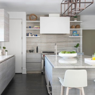 Idee per un'ampia cucina moderna con lavello sottopiano, ante lisce, ante grigie, top in granito, elettrodomestici in acciaio inossidabile, parquet scuro, isola, pavimento grigio, paraspruzzi beige e paraspruzzi in lastra di pietra