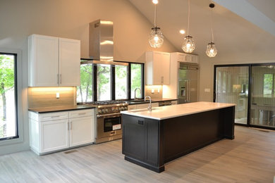 Eat-in kitchen - large contemporary single-wall ceramic tile eat-in kitchen idea in Little Rock with an undermount sink, shaker cabinets, white cabinets, granite countertops, gray backsplash, glass tile backsplash, stainless steel appliances and an island