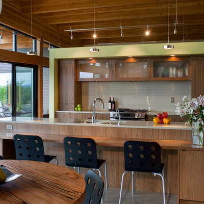 Trendy eat-in kitchen photo in Portland with an undermount sink, glass-front cabinets, medium tone wood cabinets, gray backsplash and stainless steel appliances