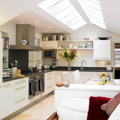 Open concept kitchen - contemporary l-shaped open concept kitchen idea in London with stainless steel appliances and white cabinets