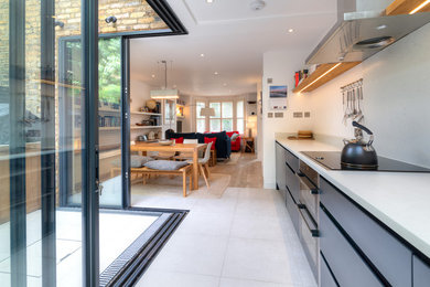 This is an example of a small modern l-shaped open plan kitchen in London with flat-panel cabinets, blue cabinets, composite countertops, grey splashback, ceramic flooring, grey floors and grey worktops.