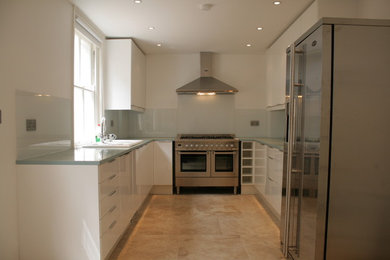 Small romantic u-shaped enclosed kitchen in London with a double-bowl sink, flat-panel cabinets, white cabinets, composite countertops, glass sheet splashback, stainless steel appliances, vinyl flooring and no island.