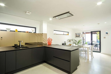 This is an example of a medium sized modern open plan kitchen in London.