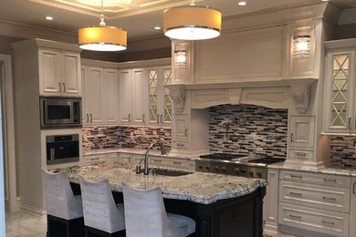 Example of a mid-sized classic l-shaped porcelain tile and gray floor eat-in kitchen design in Philadelphia with a single-bowl sink, raised-panel cabinets, gray cabinets, granite countertops, gray backsplash, glass tile backsplash, stainless steel appliances, an island and gray countertops