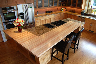 Example of a large trendy l-shaped light wood floor open concept kitchen design in Other with a double-bowl sink, shaker cabinets, light wood cabinets, granite countertops, red backsplash, glass tile backsplash, stainless steel appliances and an island