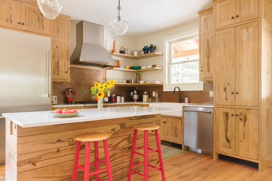 Example of a mid-sized farmhouse l-shaped brown floor and medium tone wood floor kitchen design in Nashville with a farmhouse sink, shaker cabinets, medium tone wood cabinets, quartz countertops, metallic backsplash, stainless steel appliances, an island, white countertops and metal backsplash