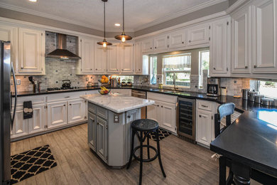 Eat-in kitchen - large transitional u-shaped porcelain tile eat-in kitchen idea in Houston with an undermount sink, recessed-panel cabinets, white cabinets, granite countertops, gray backsplash, porcelain backsplash, stainless steel appliances and an island
