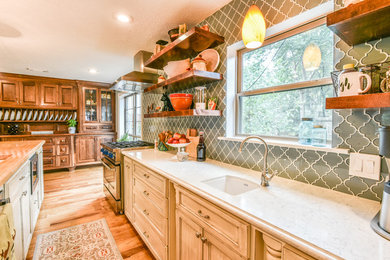 Eat-in kitchen - transitional single-wall medium tone wood floor and beige floor eat-in kitchen idea in Houston with a drop-in sink, recessed-panel cabinets, distressed cabinets, marble countertops, blue backsplash, glass tile backsplash, stainless steel appliances and an island
