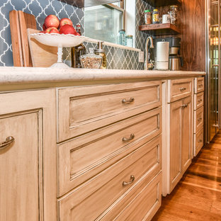 Inspiration for a transitional single-wall eat-in kitchen in Houston with a drop-in sink, recessed-panel cabinets, beige cabinets, marble benchtops, blue splashback, glass tile splashback, stainless steel appliances, light hardwood floors, with island and beige floor.