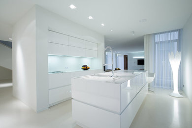 Imagen de cocina moderna grande abierta con fregadero bajoencimera, salpicadero blanco, salpicadero de losas de piedra y una isla