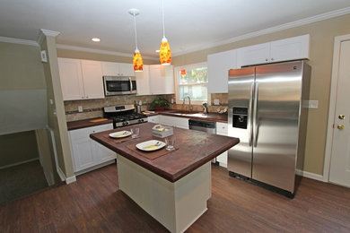 Dark wood floor kitchen photo in Other with an undermount sink, white cabinets, concrete countertops, brown backsplash, stainless steel appliances and an island