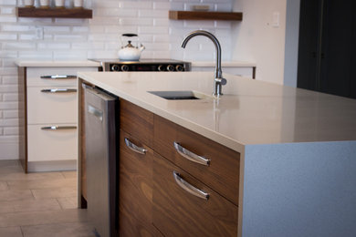 Example of a mid-sized minimalist l-shaped porcelain tile eat-in kitchen design in Toronto with an undermount sink, flat-panel cabinets, medium tone wood cabinets, quartz countertops, white backsplash, porcelain backsplash, stainless steel appliances and an island