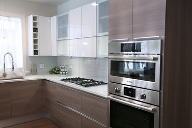 Foto de cocina moderna de tamaño medio con fregadero de un seno, armarios con paneles lisos, puertas de armario grises y electrodomésticos con paneles