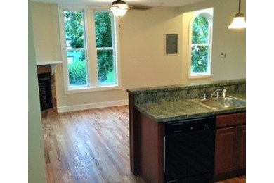 Example of a classic l-shaped medium tone wood floor eat-in kitchen design in Boston with an island