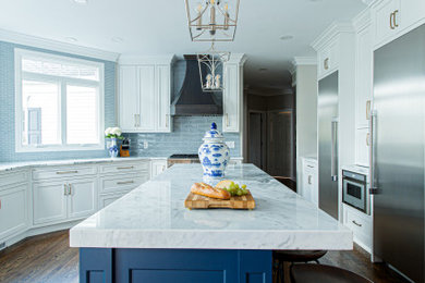 クリーブランドにあるトランジショナルスタイルのおしゃれなキッチン (アンダーカウンターシンク、シェーカースタイル扉のキャビネット、白いキャビネット、珪岩カウンター、青いキッチンパネル、セラミックタイルのキッチンパネル、シルバーの調理設備、濃色無垢フローリング、茶色い床、白いキッチンカウンター) の写真
