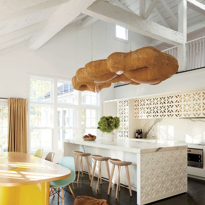 Inspiration for an eclectic galley dark wood floor and brown floor eat-in kitchen remodel in New York with flat-panel cabinets, white cabinets, white backsplash, stone slab backsplash, an island and white countertops