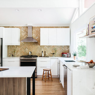 Foto di una cucina moderna con lavello sottopiano, ante lisce, ante bianche, paraspruzzi multicolore, elettrodomestici in acciaio inossidabile, pavimento in legno massello medio e top bianco