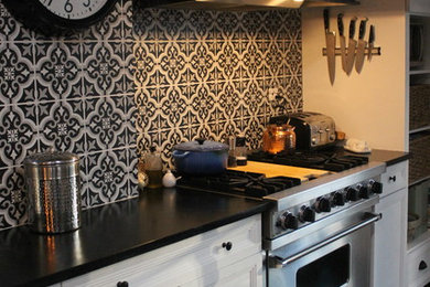 Kitchen - mid-sized country medium tone wood floor kitchen idea in New York with an undermount sink, shaker cabinets, white cabinets, soapstone countertops, ceramic backsplash, stainless steel appliances and an island