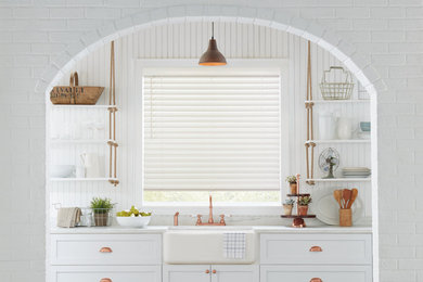 Idéer för att renovera ett mellanstort lantligt vit linjärt vitt kök, med en rustik diskho, skåp i shakerstil, vita skåp, bänkskiva i kvarts och vitt stänkskydd